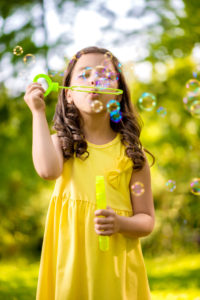 Kleines Mädchen mit Seifenblasen